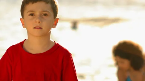 A portrait of a young boy at the beach during magic hour Stock Footage 33847784