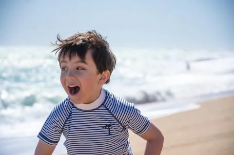 A portrait of a young boy on a beach while on holiday. Stock Photos