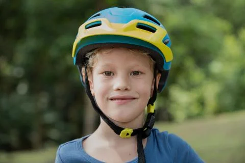 Portrait of a young boy cyclining in the park, wearing helmet Stock Photos