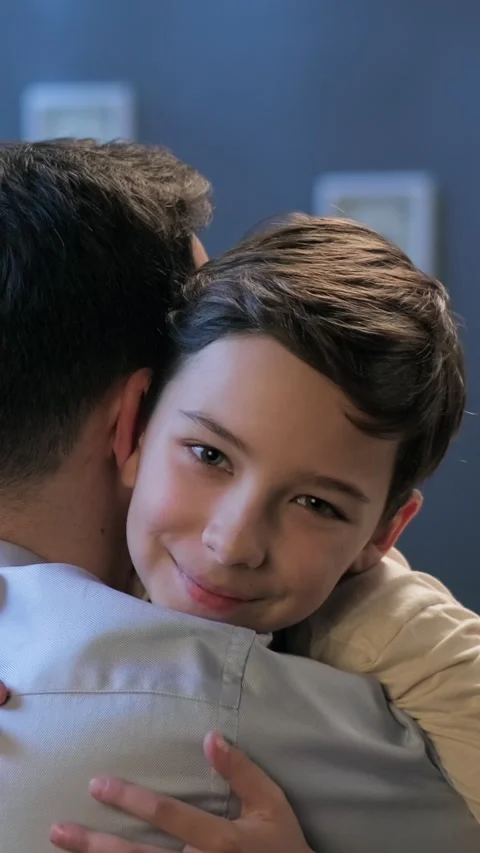 Portrait of a young boy hugging a man. Touching moment, emotional connection and Stock Footage 306856950