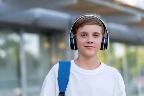 Portrait of young boy looking at camera while listening to music with headphones Fotos Stock