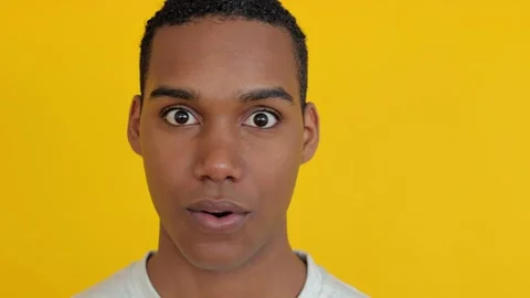 Portrait of young boy looking surprised to the camera over yellow background Stock Footage 280077172