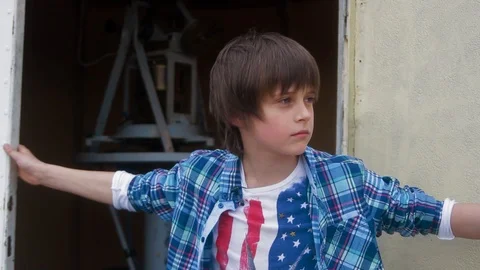 Portrait young boy opens the door look around serious look to camera talk speak Stock Footage 98215180