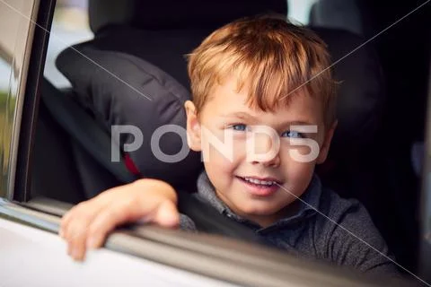 Portrait Of Young Boy Sitting In Child Safety Seat On Car Journey Looking Out Of Stock Photos