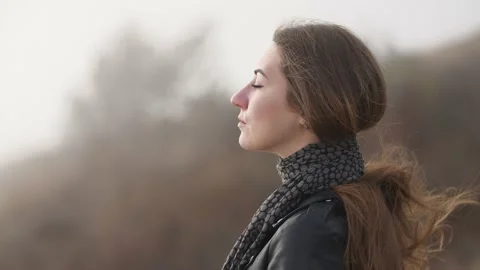 Portrait of a young brooding woman in profile who smiles against the backdrop of Stock Footage 132040480