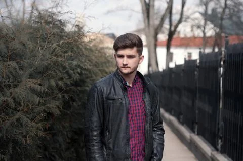 Portrait of a young brutal man with hipster hairstyles wearing leather jacket Stock Photos