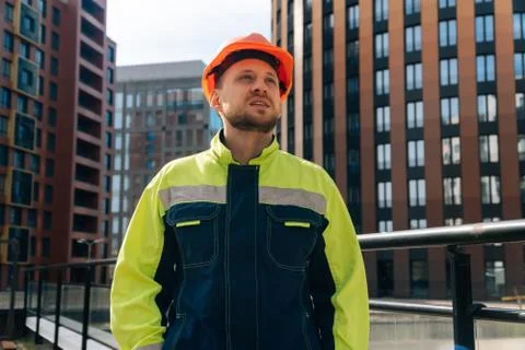 Portrait of a young builder in special clothes, male engineer thinking about  Stock Photos