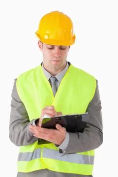 Portrait of a young builder taking notes Stock Photos