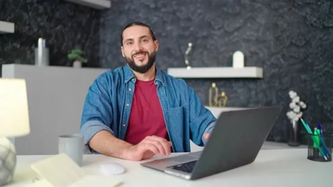 Portrait of young businessman is typing on a computer and smiling at the camera Stock Footage 236587994