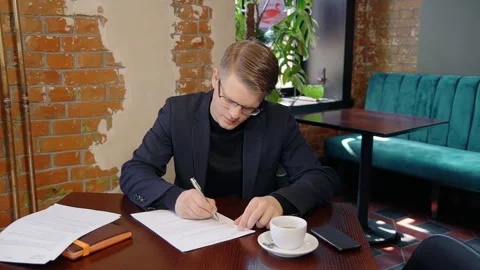 Portrait of young businessman working on documents in cafe. Stock Footage 89953892