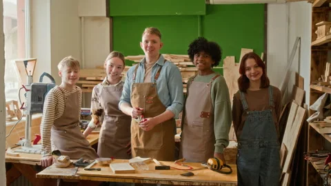Portrait of Young Carpenter and Group of Teenagers Smiling during Masterclass Stock Footage 334430807