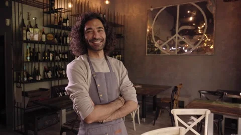 Portrait of a young caucasian man looking at camera in a restaurant. Proud and Stock Footage 243677869