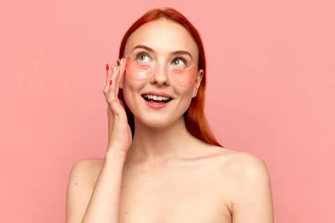 Portrait with young charming girl with bare shoulders using eye patches for skin Foto stock