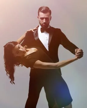 Portrait Of Young Couple Dancing Over Grey Background Fotos Stock