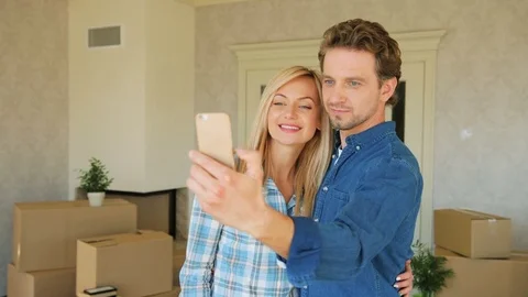 Portrait of young couple making selfie on the smart phone in new apartment after Stock Footage