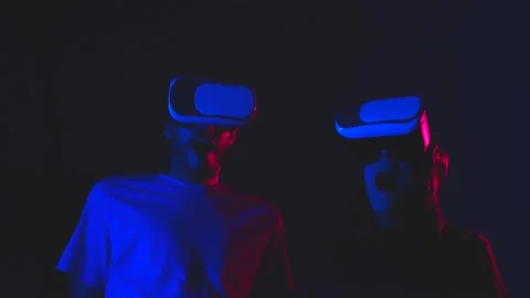 Portrait of young couple playing with virtual reality goggles in a dark room Stock Footage 148986663
