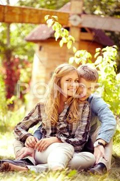 Portrait of young couple sitting on grass and smiling at camera Stock Photos