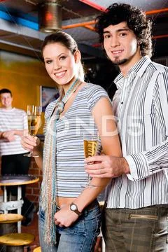 Portrait of young couple standing and holding the glasses of white wine Stock Photos