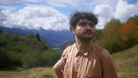 Portrait of a young curly-haired guy who is looking at a landscape with Vidéo 194056551