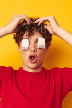 Portrait of a young curly man posing emotions tea bags isolated background Stock Photos