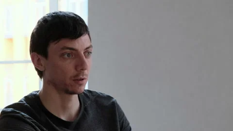Portrait of young dark-haired man talking to someone outside the frame 動画素材 135743688