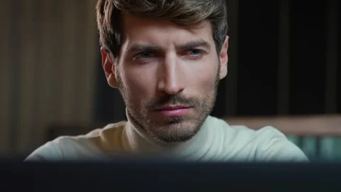 Portrait of a young developer working on a laptop, focused man looks at the Stock Footage 279139147
