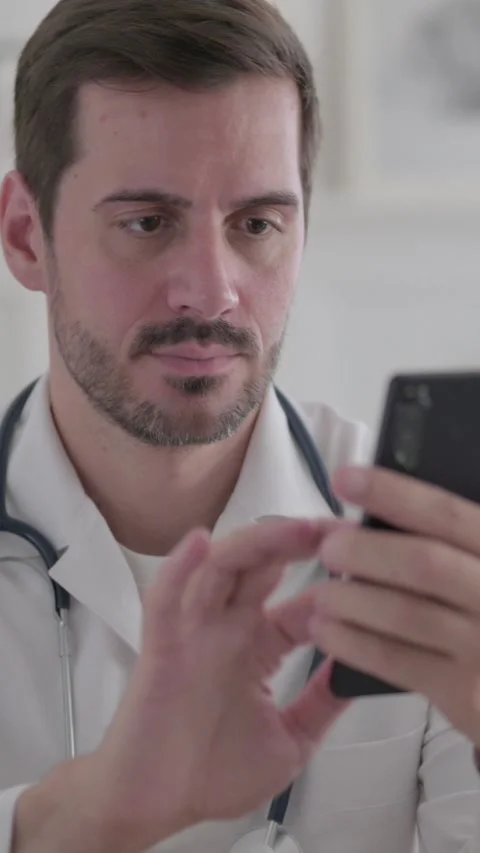 Portrait of Young Doctor using Smartphone, Vertical Video Video stock 328968341