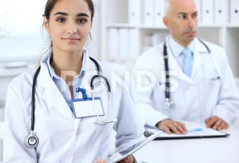 Portrait of young doctor woman in hospital. Hispanic or latin american staff i Stock Photos