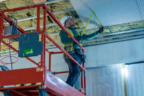 Portrait of young drylining contractor installing ceiling on construction site Stock Photos