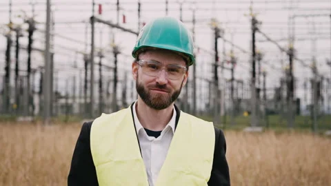 Portrait of young electric engineer wearing helmet suit and safety vest at bad Stock Footage 171547717