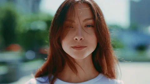 Portrait of young elegant ginger lady standing on beautiful sunny street. Very Video stock 157921600