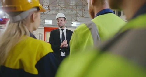 Portrait of young factory manager talking to group of workers Video stock 112059489