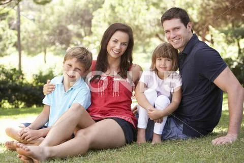 Portrait Of Young Family Relaxing In Park Stock-Fotos
