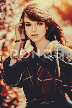 A portrait of a young fashionable woman in the park. Beauty, fashion. Stock Photos