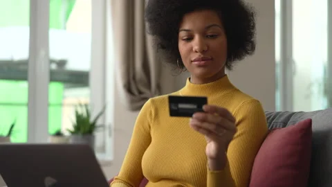 Portrait of young female client doing online shopping and sitting on sofa in Stock Footage 182944990