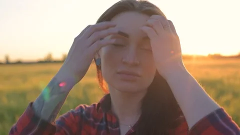 Portrait of young female looking at camera in wheat field during sunset Stock Footage 90082988
