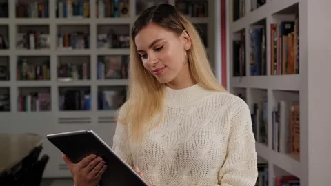 Portrait of a young female student in the library with a tablet. Stock Footage 145204952