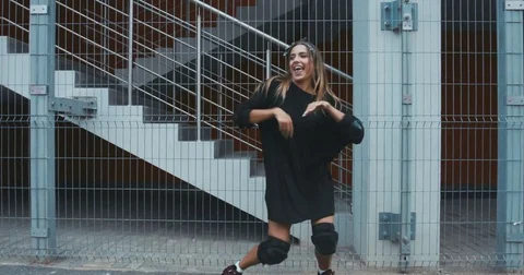 Portrait of young female in stylish outfit practicing dance moves in the city Stock Footage