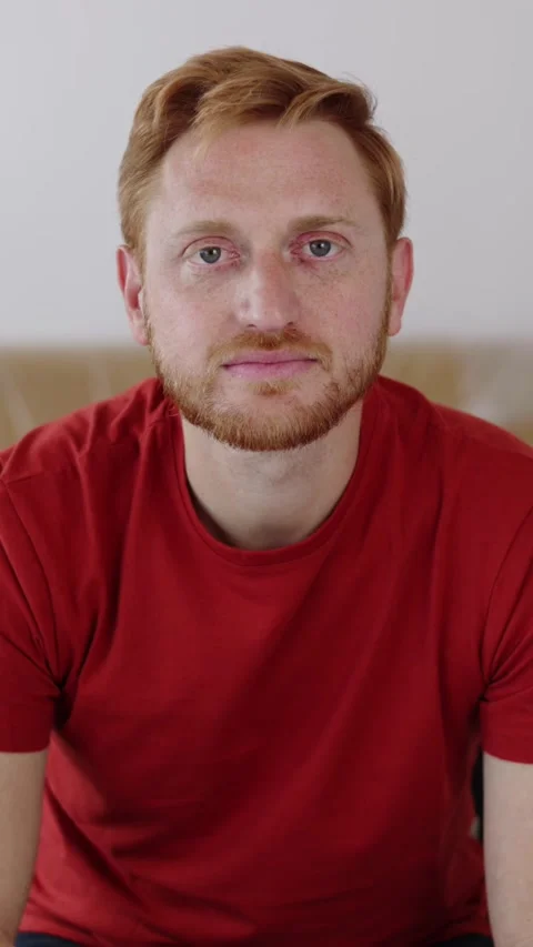 Portrait of young ginger man looking at camera standing at new loft apartment Stock Footage 312198708