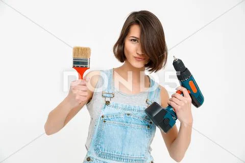 Portrait of young girl, holding painting brush and drill Stock Photos