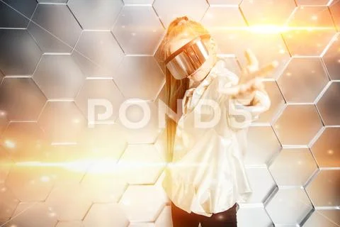 A portrait of a young girl in a silver cloak and virtual reality glasses on b Stock Photos