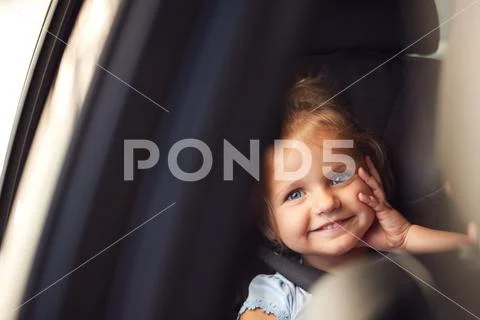 Portrait Of Young Girl Sitting In Child Safety Seat On Car Journey Looking Out Stock Photos