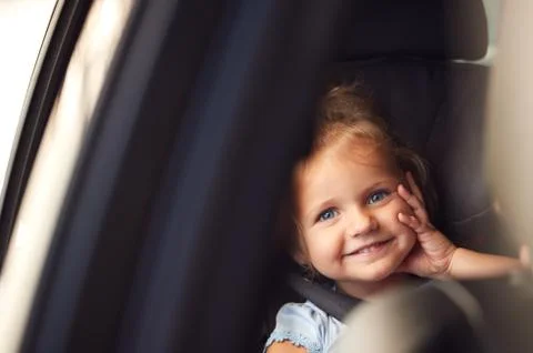 Portrait Of Young Girl Sitting In Child Safety Seat On Car Journey Looking Out Stock Photos