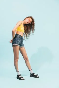 Portrait of young girl wearing jeans shorts, yellow top and trendy pink Stock Photos