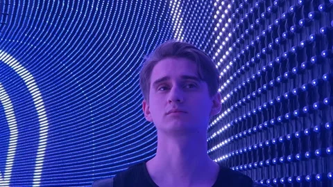 Portrait of a young guy in a corridor with neon lighting Stock Footage 315694375