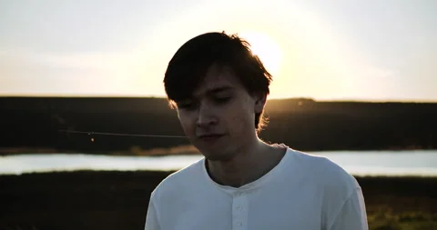 Portrait of a young guy on a sunset background Stock Footage 153880022