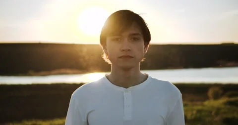 Portrait of a young guy on a sunset background Stock Footage 153880441