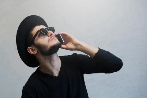 Portrait of young guy who using smartphone over white background, wearing Stock Photos