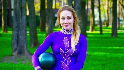 Portrait of a young gymnast smiling to the camera in the park slow motion Stock Footage 75424480