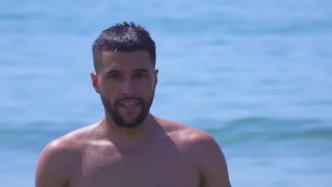 Portrait of a young handsome man on the background of the sea surf Stock Footage 124856084